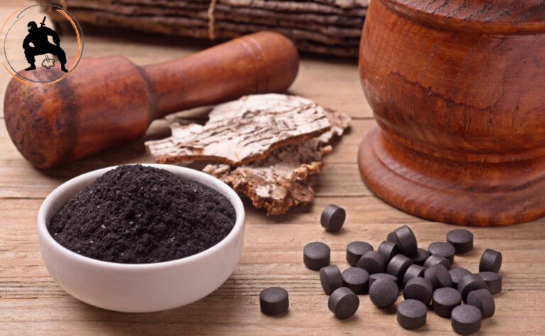 węgiel aktywny jako środek na śmierdzące gazy i wzdęcia, kupka tebletek węgla aktywnego, obok moździeż pełen pokruszonych na miał węglowy tabletek